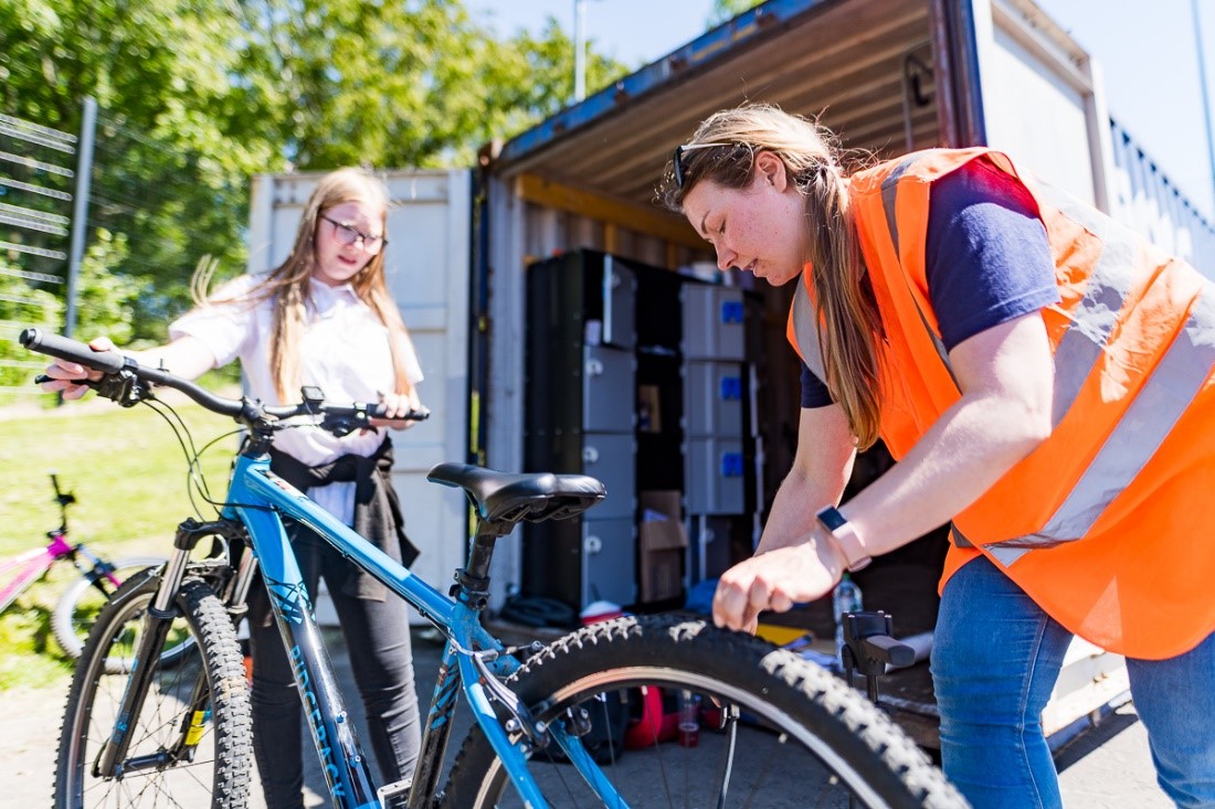 Photo os I Bike staff helping a teenage pupil with bike safety checks